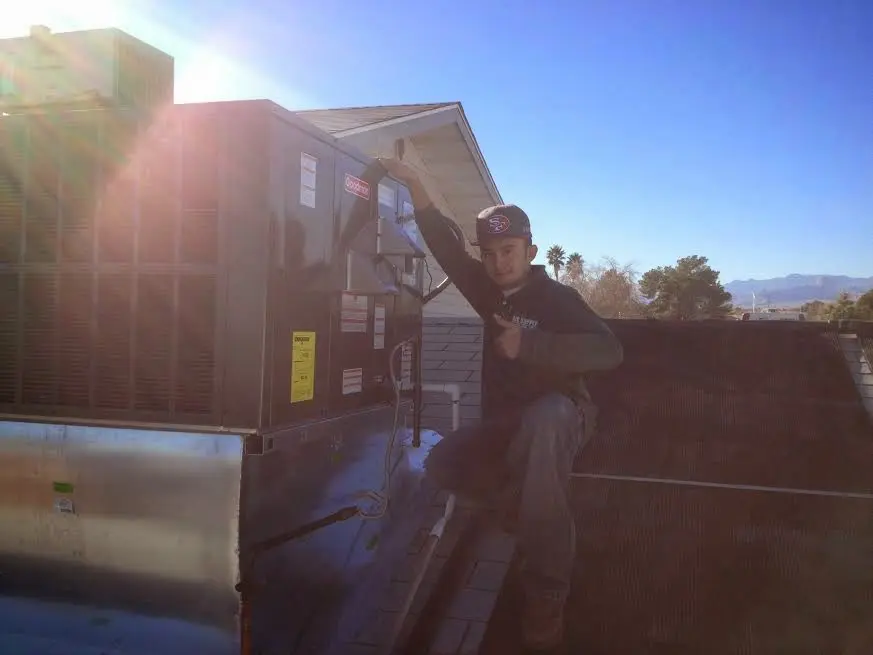 HVAC technician performing AC Tune-Up on a rooftop unit in South Londonderry